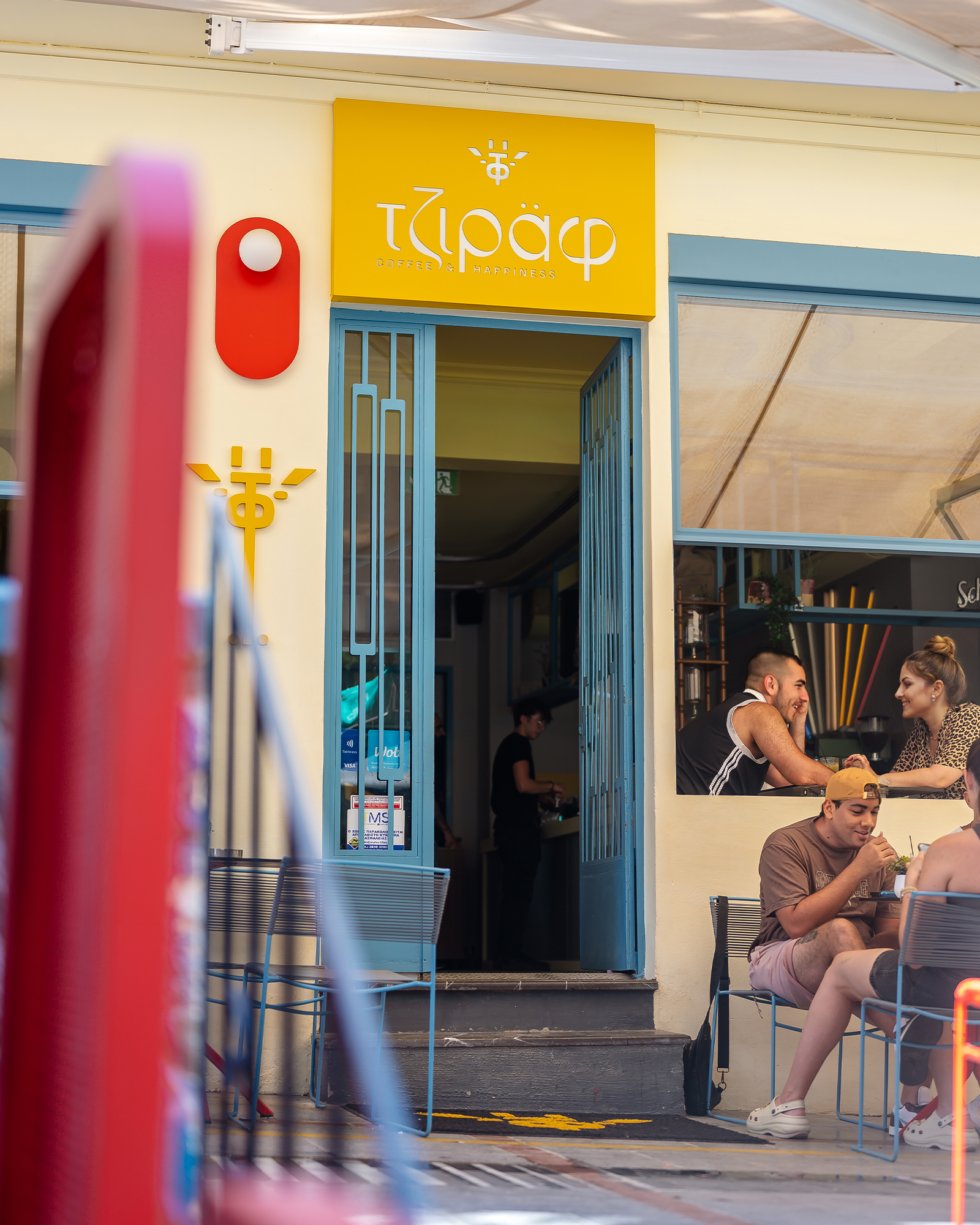 The bright yellow interior of Tziraf Coffee & Happiness in Heraklion