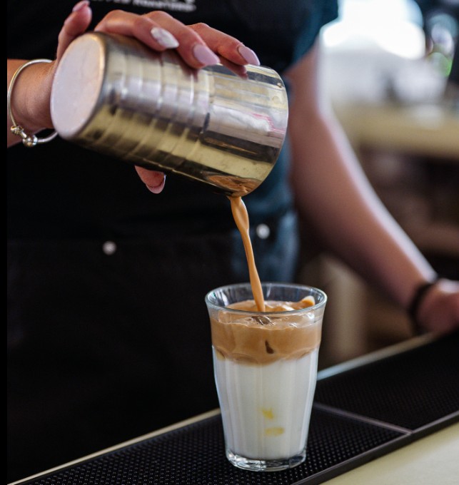 Specialty coffee in a cup with the Tziraf logo