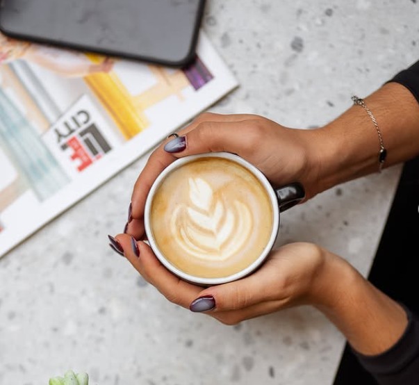 A latte in a glass on a Tziraf table